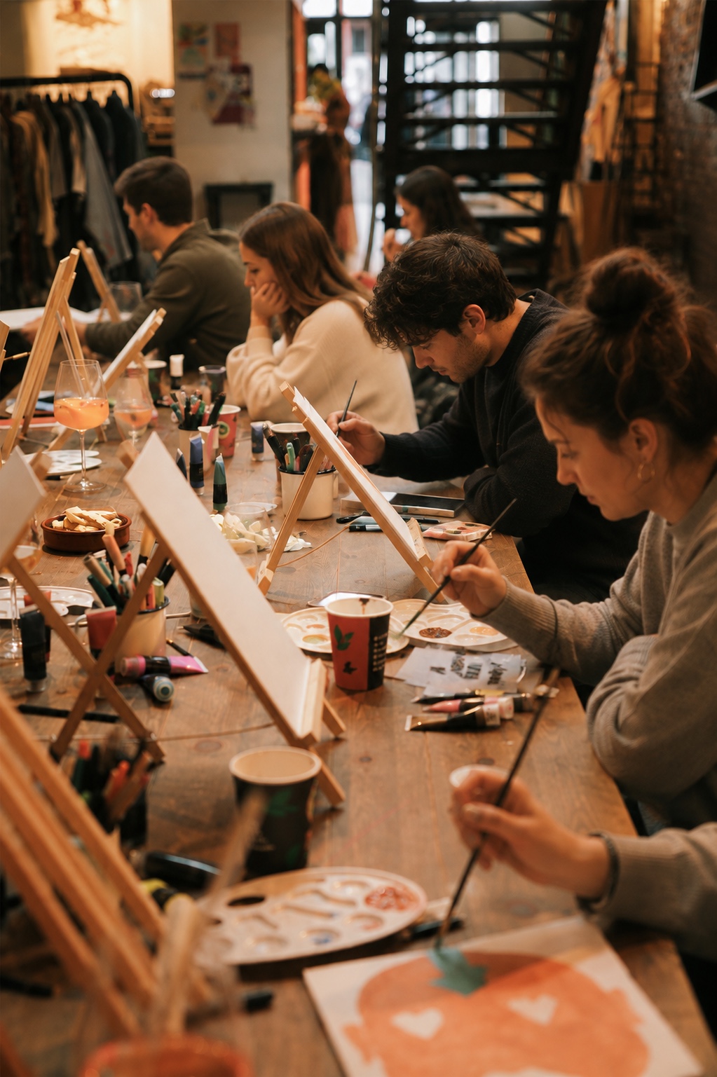 Llenços, cavallets i una copa de vi durant Pintura i vi