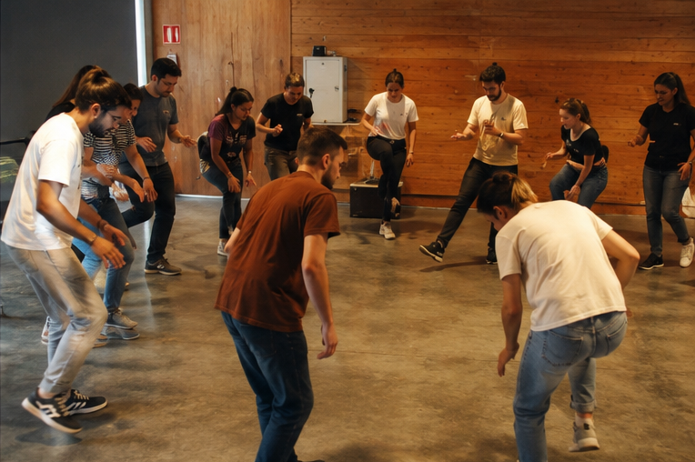 Participants practicant passos i moviments al centre de la sala