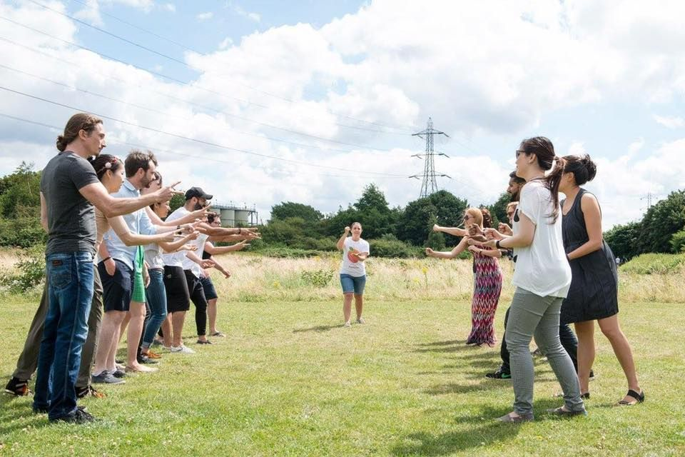Dos grups enfrontats participant en una dinàmica amb les mans