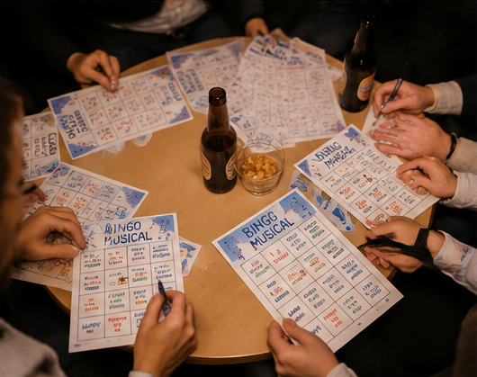 Vista zenital de mans, cartrons i material de Bingo musical sobre una taula