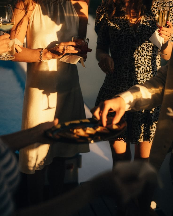 Persones compartint copes i un aperitiu amb llum de tarda