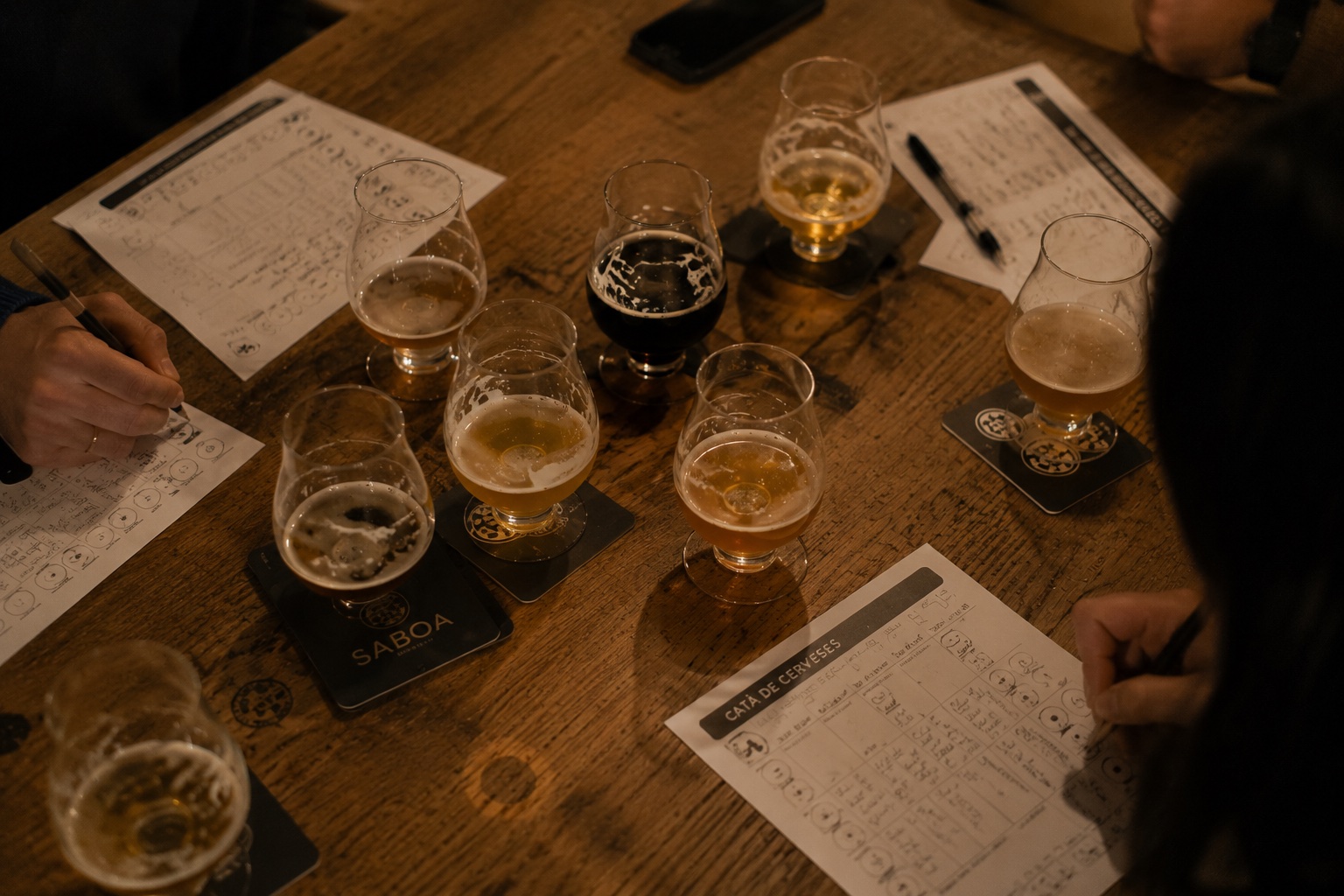 Taula de cata amb cerveses, fitxes i anotacions dels participants